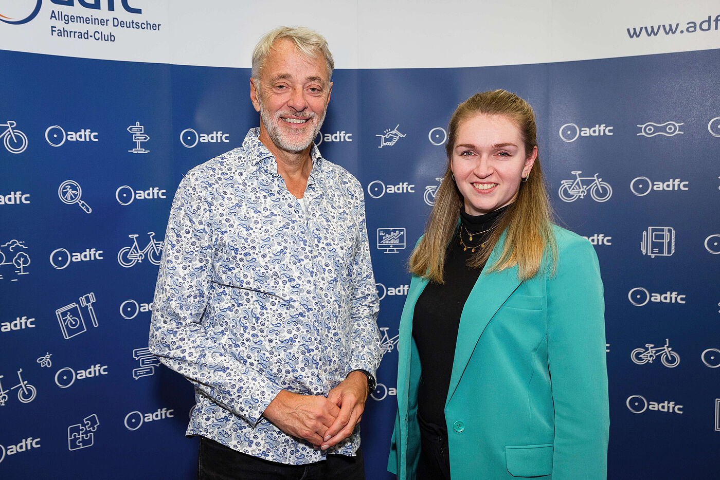 Der neue ADFC-Bundesvorsitzende Frank Masurat und Rebecca Peters stehen vor einer Fotowand.